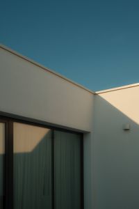 Kaboompics - Modern White Building Facade with Angular Sunlight and Blue Sky