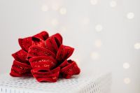 Kaboompics - Single Red Glitter Gift Bow with Soft Bokeh and White Copy Space