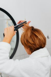 Kaboompics - Back View of a Woman Straightening Short Hair with a Flat Iron