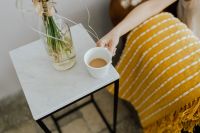 Kaboompics - A woman puts a cup of coffee on a marble table