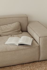 Kaboompics - Open Book on Neutral Gray Sofa in Cozy Living Room