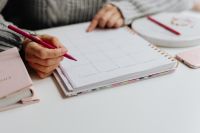 Kaboompics - Close-Up of Woman Writing in a Planner with Pink Pencil