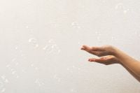 Kaboompics - Cupped Hands Reaching toward Soap Bubbles on a White Wall