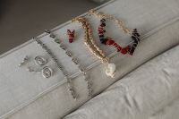 Kaboompics - Silver and Beaded Jewelry Arranged on a Sofa