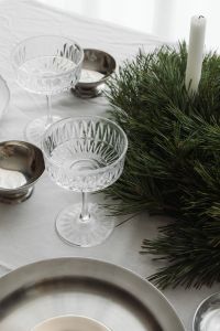 Kaboompics - Minimal Place Setting with White Wrapped Gift, Silver Pitcher and Crystal Coupe