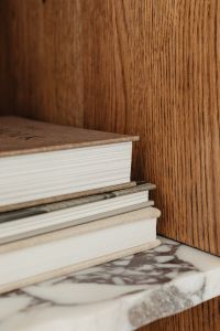 Kaboompics - Close-Up of a Brown Hardcover Book on a Walnut Bookshelf