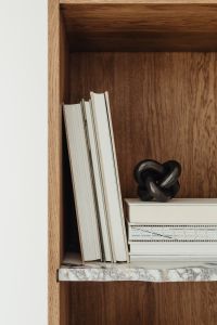 Kaboompics - Neutral Bookshelf Styling with White Books, Marble Shelves and Sculptural Decor