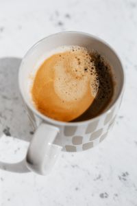 Kaboompics - Patterned Ceramic Mug with Morning Coffee and Marble Shadows