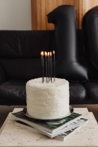Kaboompics - White Cake with Black Candles in Front of a Leather Sofa