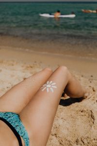 Kaboompics - Sun-Shaped Body Paint on a Woman Lying on the Sandy Beach