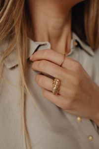 Kaboompics - Woman Holding Tan Silk Shirt Collar with Gold Rings