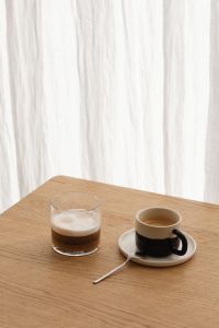 Kaboompics - Overhead Foamy Coffee in a Glass Cup on a Beige Stone Block