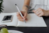 Kaboompics - Overhead Notebook Writing With Smartphone in Office