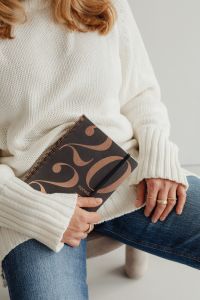 Kaboompics - Faceless Woman in White Sweater Holding a Patterned Book