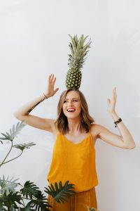 Kaboompics - Smiling Woman with a Pineapple on Her Head and Open Space, Bright Fresh Food Lifestyle