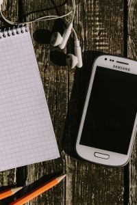 Kaboompics - Nostalgic Samsung Phone, Earphones and Stationery Flat Lay