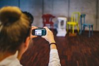 Kaboompics - Woman in glasses taking a photo with a camera