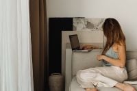 Kaboompics - Woman Working on a Laptop Beside a Sofa at Home