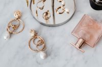 Kaboompics - Gold Pearl Drop Earrings and Pink Perfume Bottle on Marble, Horizontal Beauty Flat Lay