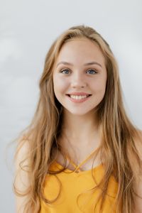 Kaboompics - Smiling Blonde Teen Girl Headshot on a Light Background