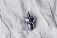 Kaboompics - Two Metallic Christmas Ornaments on Wrinkled White Textile