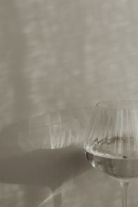Kaboompics - Cropped Ribbed Water Glass and Window Shadow on a Beige Wall
