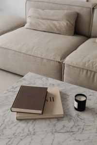Kaboompics - Beige Sofa and Cushions with Books and Candle on Marble Table