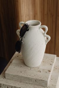 Kaboompics - Black Sunglasses Hanging on a White Ceramic Vase