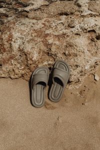 Kaboompics - Taupe Slide Sandals on Sand Near Shoreline Rocks
