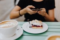Kaboompics - The woman takes a picture of the cake with her phone