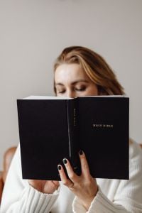 Kaboompics - Close-Up of Woman Looking Down into a Black Holy Bible