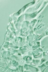 Kaboompics - Glossy Transparent Gel Texture with Light Reflections on Green Background