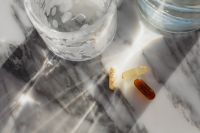 Kaboompics - Tablets and Supplement Capsules Beside a Glass
