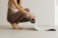 Kaboompics - Woman Crouching While Unrolling a Yoga Mat