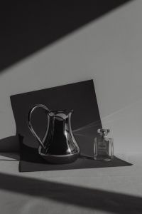 Kaboompics - Black and White Perfume Bottle and Silver Pitcher