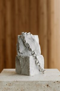 Kaboompics - Silver Chain Hanging on Textured Stone Blocks