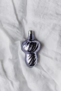 Kaboompics - Cropped Metallic Violet Ornament on Textured White Fabric