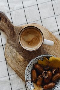 Kaboompics - Coffee Cup with Bowl of Acorns on a Wooden Board