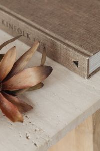 Kaboompics - Close-Up of a Kinfolk Book Cover and Dried Flower on Travertine