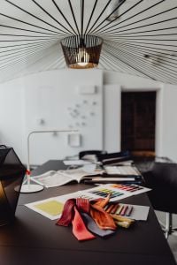 Modern Interior Design Studio with Laptop, Sample Books, Textiles and Office Chair