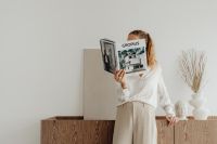 Kaboompics - Woman Holding Gropius Architecture Book in a Neutral Living Room with Dried Pampas