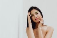 Kaboompics - Asian Beauty Portrait Touching Her Face with Green Eyebrow Makeup and Copy Space
