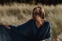 Kaboompics - Faceless Woman in Blue Dress Sitting in Coastal Dunes