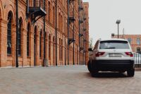 Kaboompics - White SUV beside Long Arched Brick Factory Facade at Manufaktura, Łódź, Poland