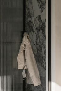 Kaboompics - Beige Jacket Hanging in Minimal Marble Interior