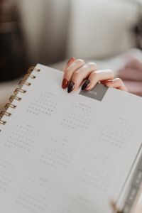 Kaboompics - Writing in a notebook lying in bed, with coffee, candles, and gingerbreads
