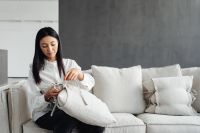 Kaboompics - Woman Arranging Cushions on a Linen Sofa