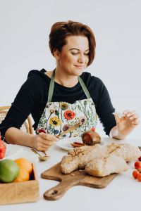 Kaboompics - Woman Eating at a Table with Rustic Bread and Fresh Fruit