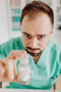 Kaboompics - Doctor Holding Clear Pill Bottle Toward Camera