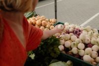 Kaboompics - Woman Holding Fresh Onions at a Farmers Market